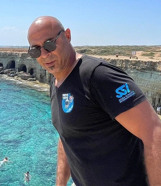 Mario, diving instructor, on the cliffs above the turquoise sea in Cyprus